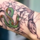 Revisão da tatuagem masculina com cobras no braço